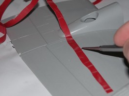 Image of a model maker scribing panel lines on a plastic model plane