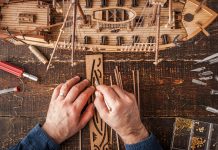 Image of man building a scale model ship, as part of a blog about DIY projects and scale modelling.
