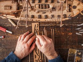 Image of man building a scale model ship, as part of a blog about DIY projects and scale modelling.